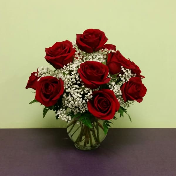 Red roses and white baby's breath in a clear glass vase