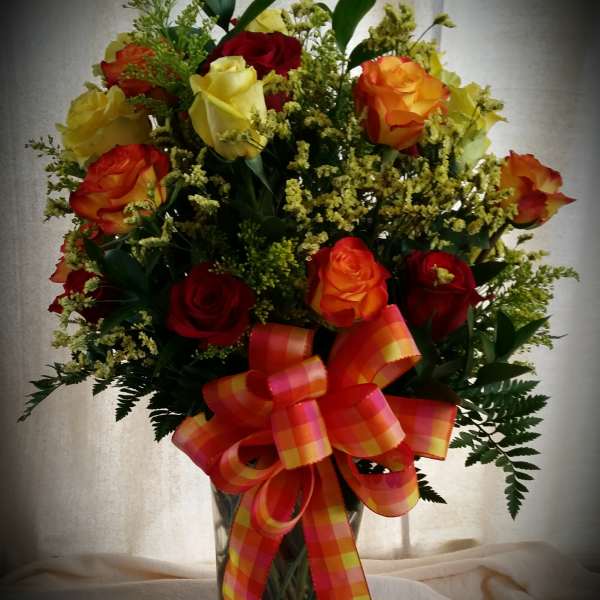 Two dozen mixed color roses arranged in a vase