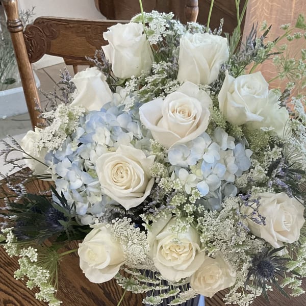 White roses and pale blue hydrangeas in a bouquet