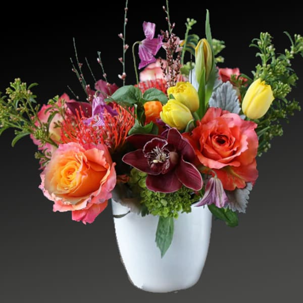 Colorful mixed flower arrangement in a white vase