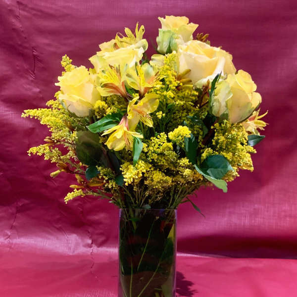 Yellow roses and alstroemeria in a clear glass vase
