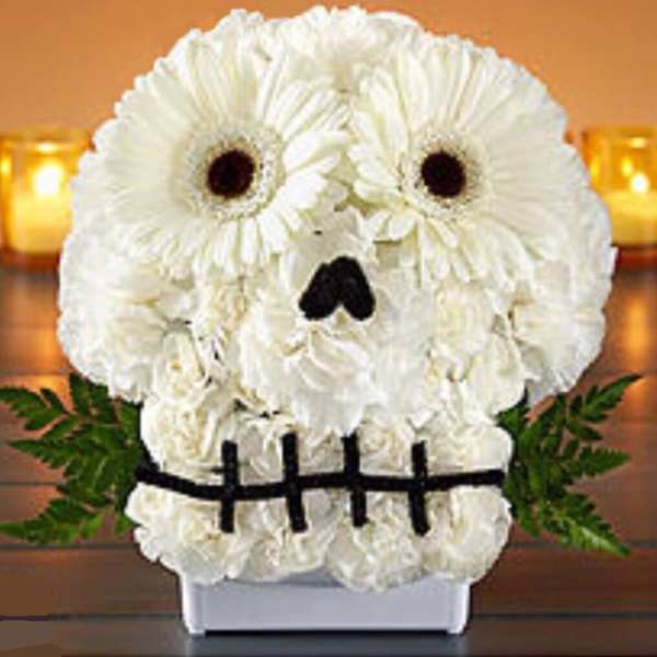 White flower arrangement shaped like a skull with dark eye and nose accents