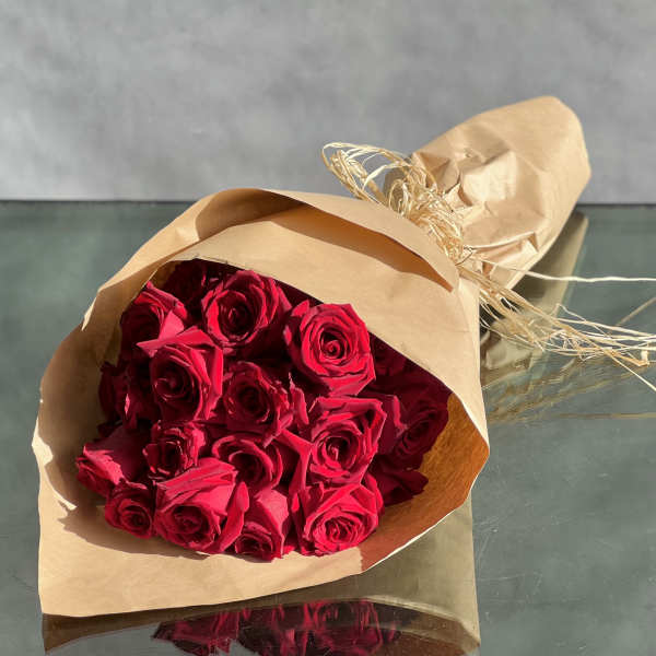 Bouquet of red roses wrapped in brown paper