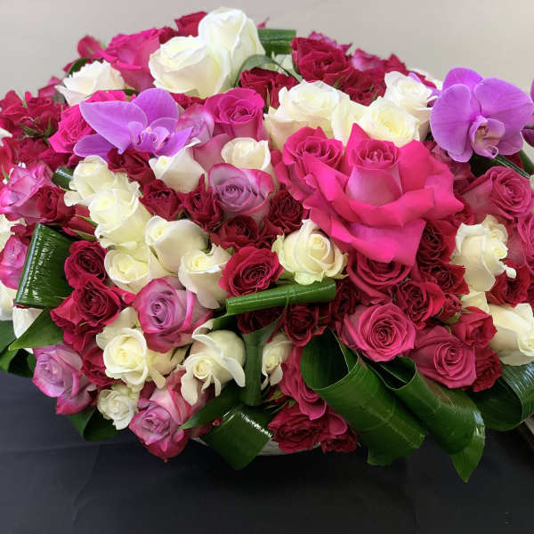 Large bouquet of pink, white, and purple roses with orchids