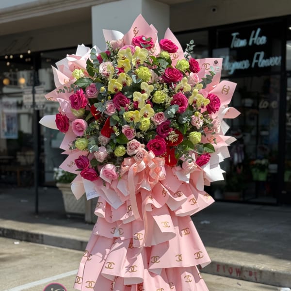 Large pink bouquet with roses and orchids on a stand