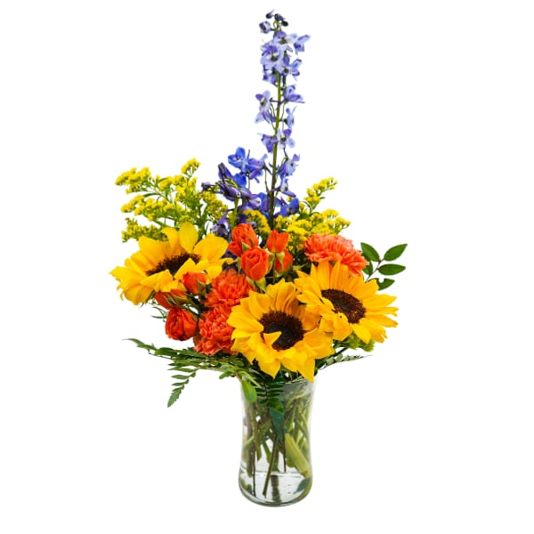 Bouquet of sunflowers, orange roses, and blue delphinium in a glass vase