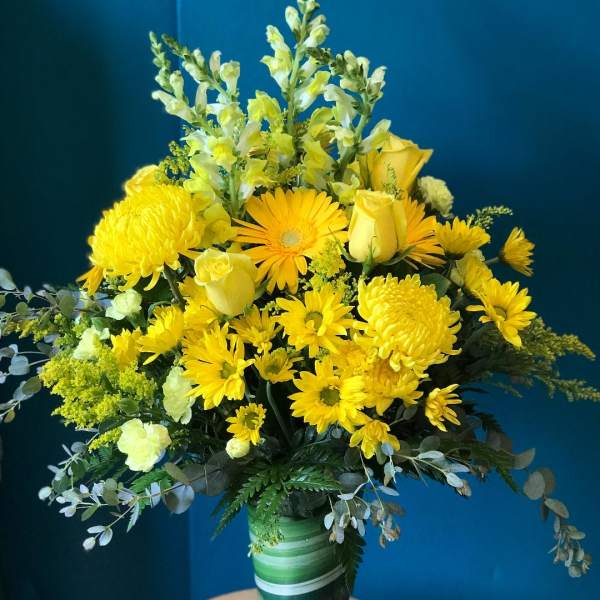 Yellow flowers arranged in a clear glass vase
