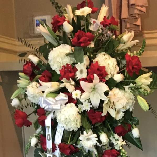 Large standing spray of red and white flowers on an easel