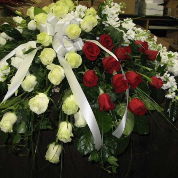 Large floral spray of red and white roses with white ribbon