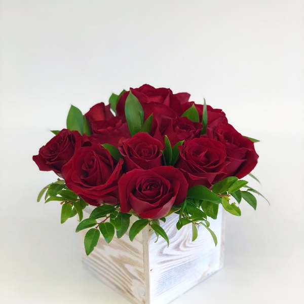 Red roses arranged in a white wooden box