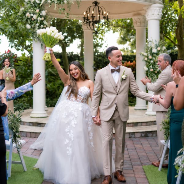 Bride and groom at a wedding ceremony with a white tulip bouquet