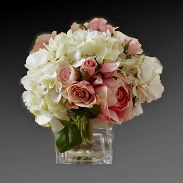 Pink roses and white hydrangeas in a clear square vase