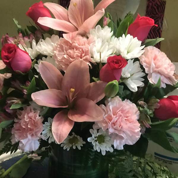 Pink lilies, roses, carnations, and white daisies in a vase