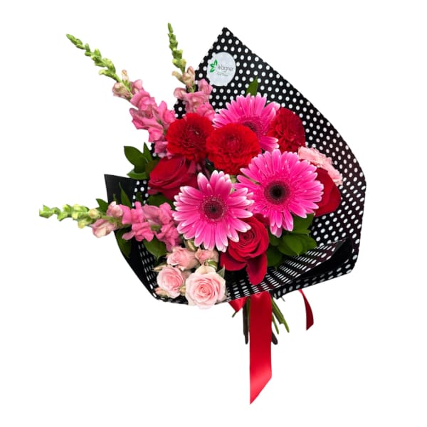 Bouquet of pink and red flowers wrapped in black polka-dot paper