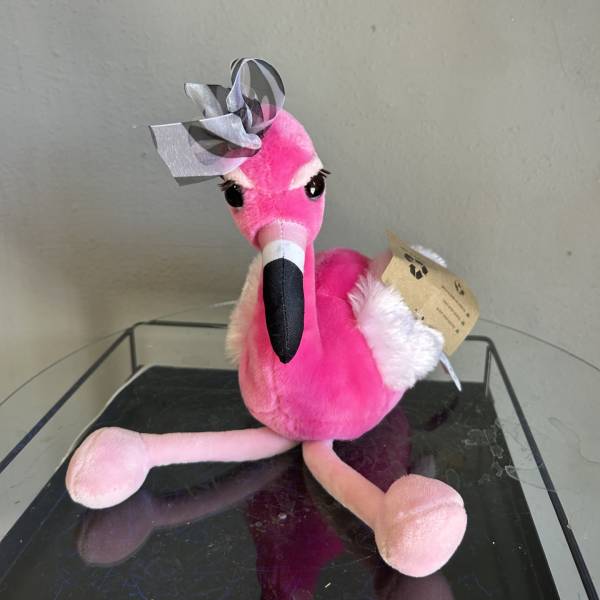 Pink flamingo plush toy with a ribbon bow on its head