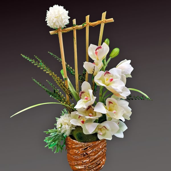 White orchid arrangement in a copper textured pot with bamboo accents