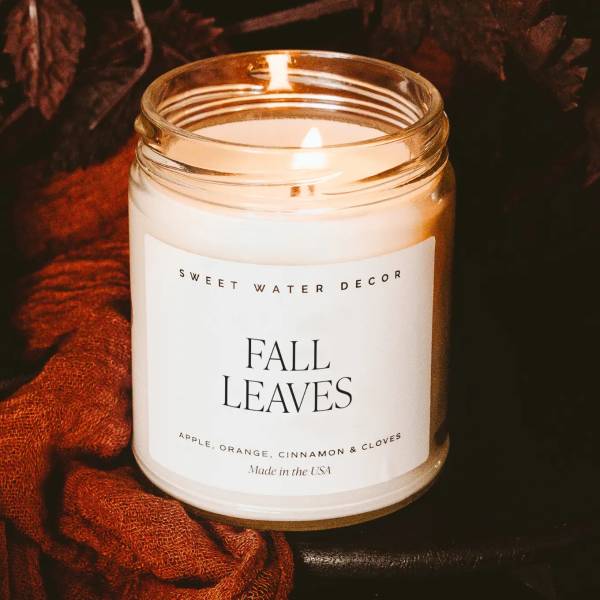 Lit candle in a glass jar labeled Fall Leaves