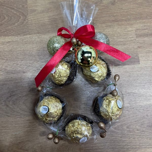 Chocolate truffles wrapped in clear plastic with a red ribbon