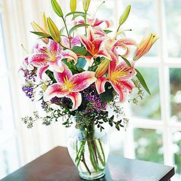 Pink stargazer lilies arranged in a clear glass vase