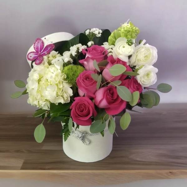 Pink and white rose arrangement in a white hatbox
