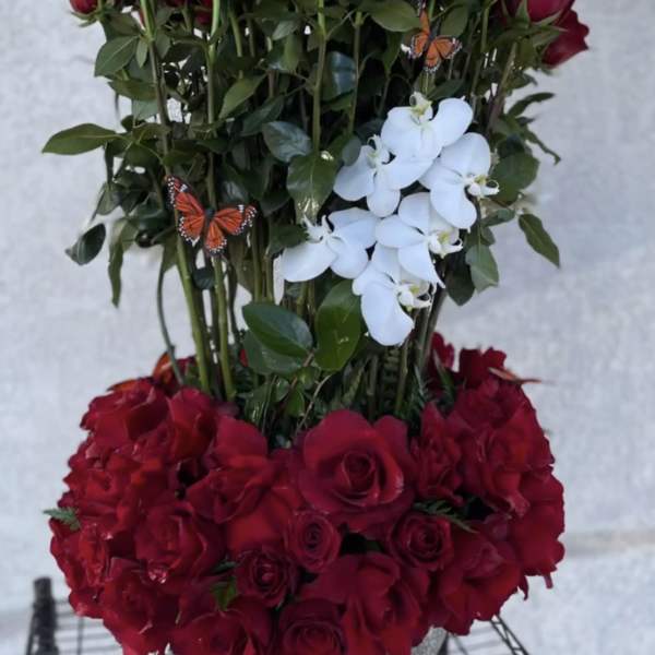 Tall red rose arrangement with white orchids in a silver vase