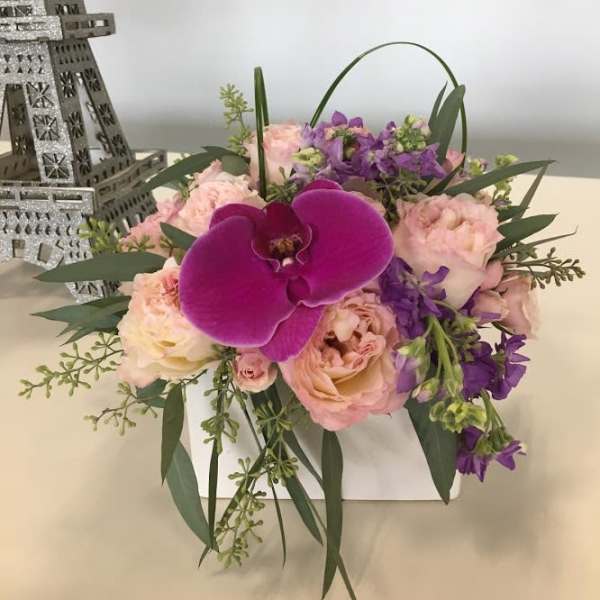 Pink and purple bouquet with a large orchid bloom in a white box