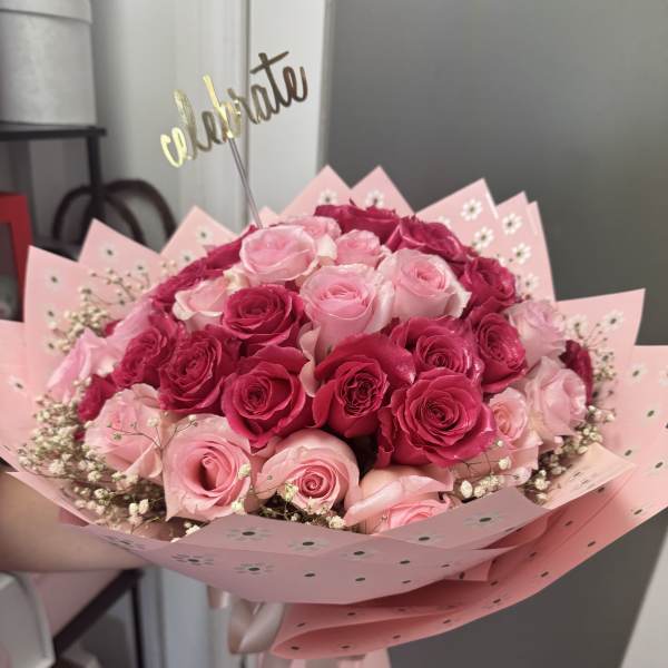 Bouquet of pink and hot pink roses wrapped in pink paper