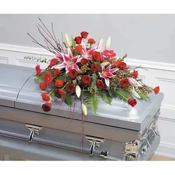 Red and pink floral casket spray with lilies and roses
