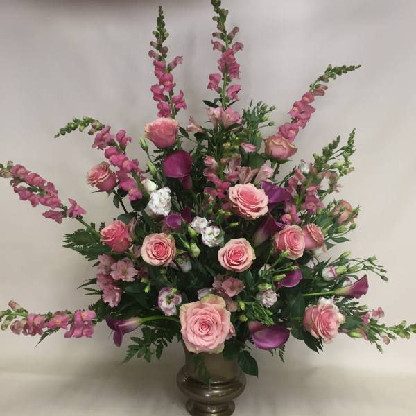 Pink roses and purple calla lilies in a glass vase