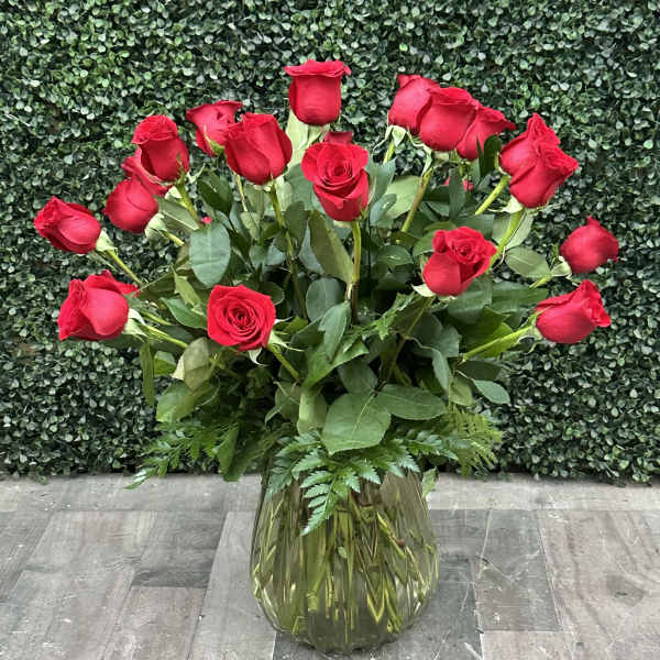 Red roses arranged in a clear glass vase