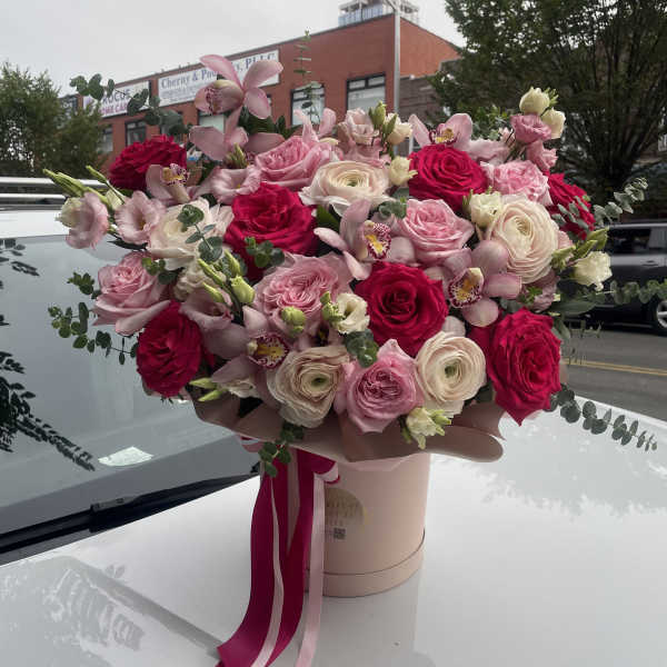 Large pink and white rose bouquet with orchids in a hat box