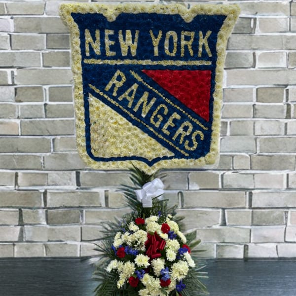 Floral tribute shaped like the New York Rangers logo with a flower base
