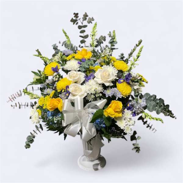 Bouquet of yellow and white flowers with a white ribbon in a vase