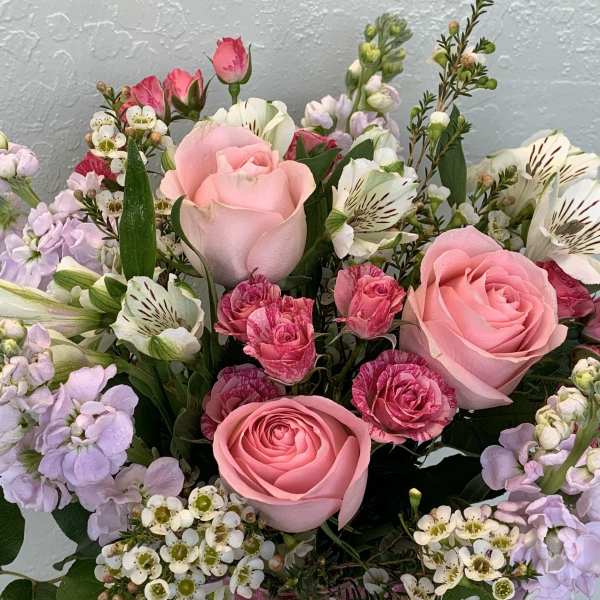 Pink roses with lavender and white mixed flowers in a bouquet
