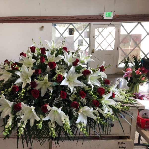 Large floral spray with white lilies and red roses on a table
