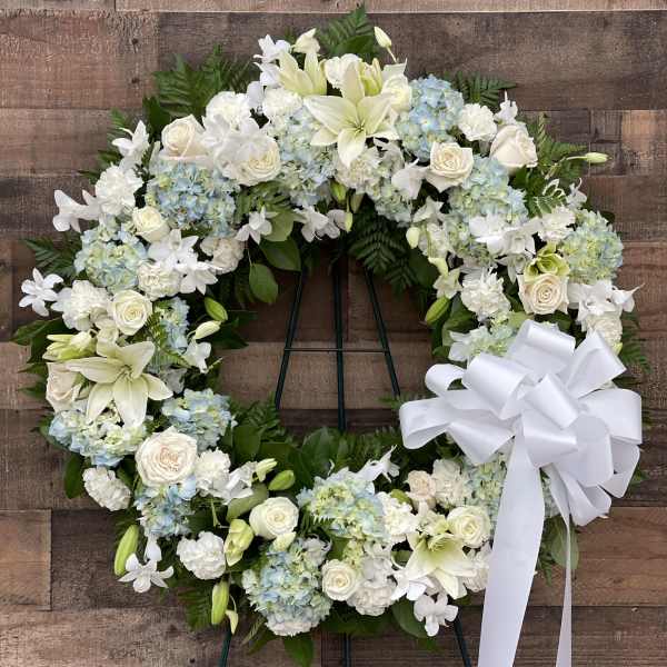 White and pale blue floral wreath with a large white bow