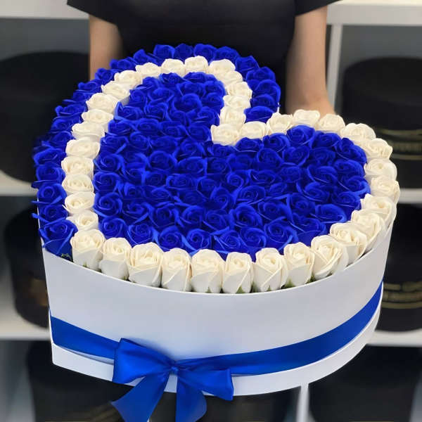 Heart-shaped box of blue and white roses with a blue ribbon
