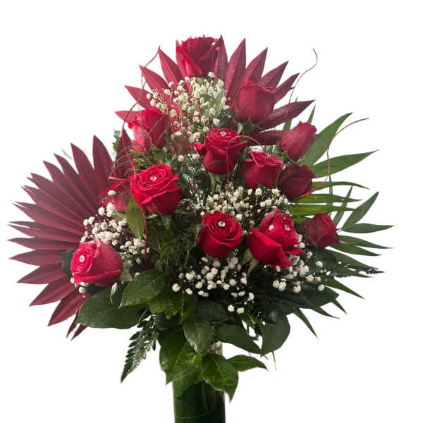 Red roses arranged in a clear glass vase with white filler flowers