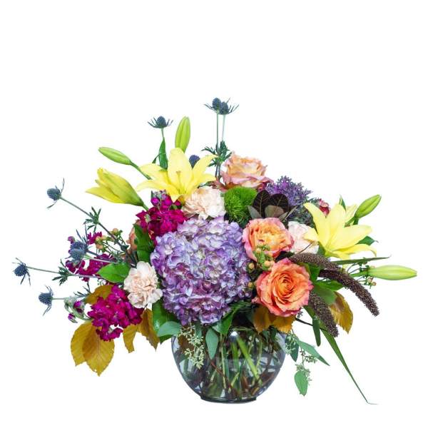 Mixed bouquet with hydrangea, lilies, roses, and carnations in a glass vase