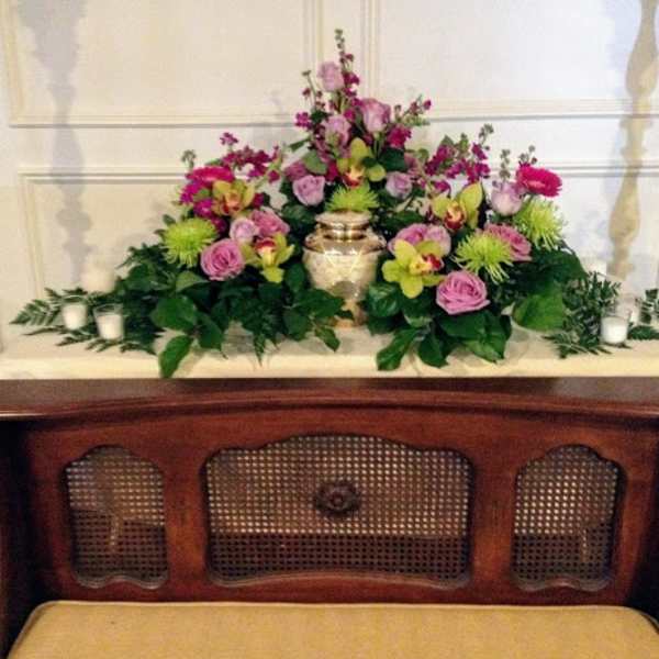 Pink and green floral arrangement with a gold urn centerpiece