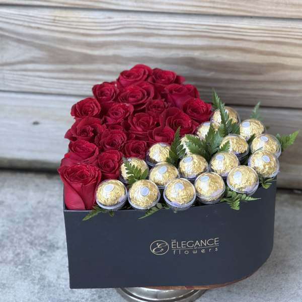 Red roses and gold-wrapped chocolates in a black box