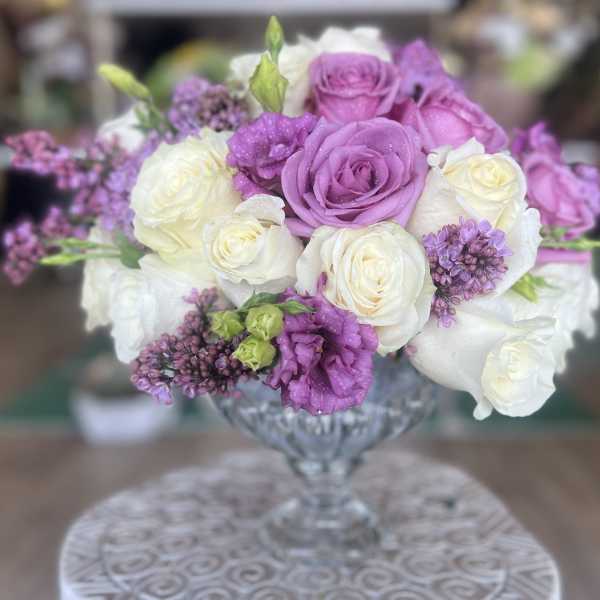 Lavender and white roses arranged in a clear glass vase