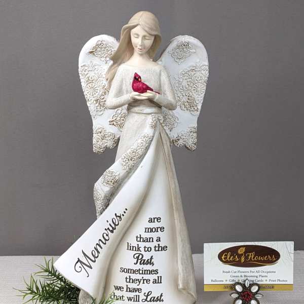 Decorative angel figurine holding a red bird with a memorial message on the dress