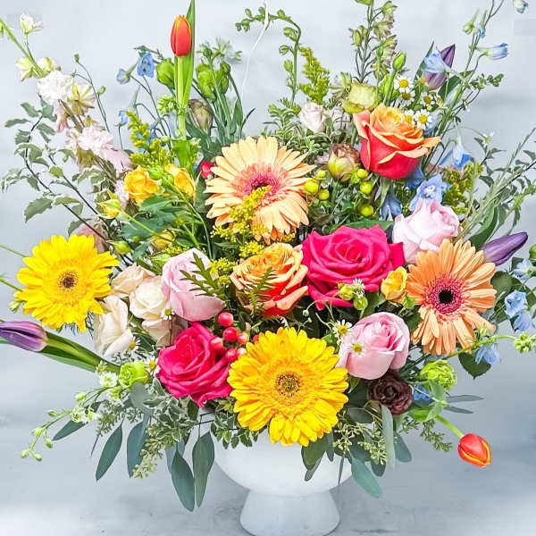 Colorful mixed bouquet in a white pedestal vase
