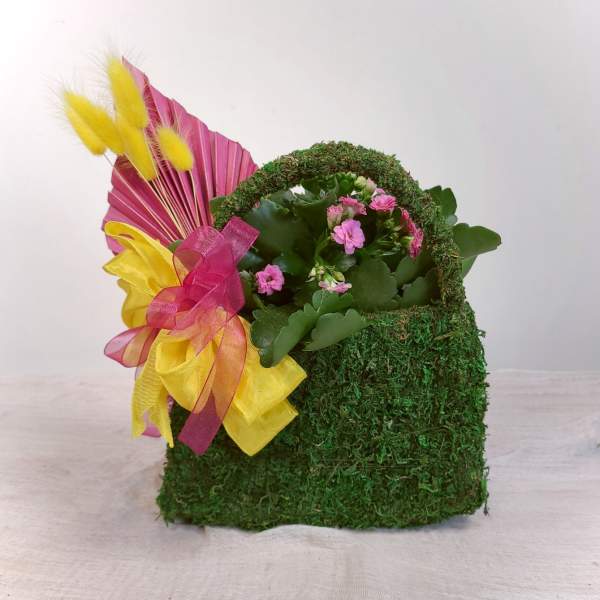 Moss-covered basket with pink flowers and yellow decorative accents
