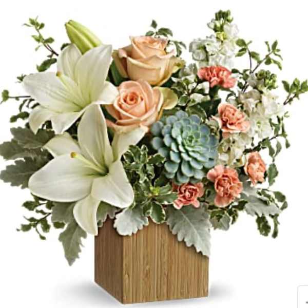 Arrangement of white lilies, peach roses, and a blue succulent in a wooden vase