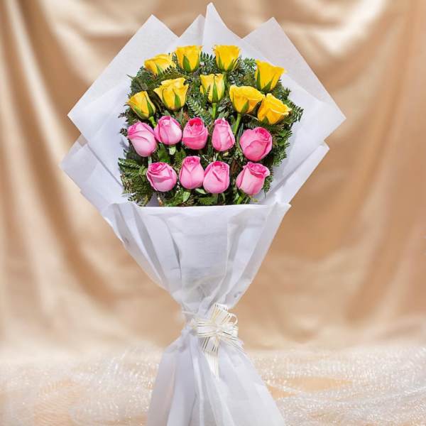 Bouquet of pink and yellow roses wrapped in white paper