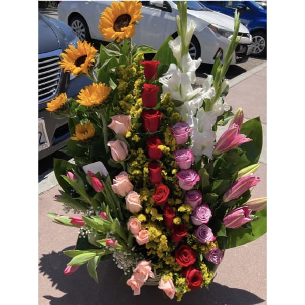 Cascading floral arrangement with sunflowers, roses, lilies, and tulips