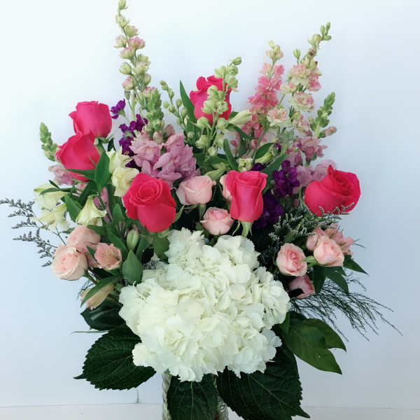 Mixed pink and white flowers arranged in a glass vase