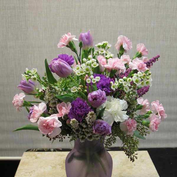Pink and purple mixed bouquet in a purple vase